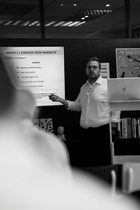 Andy Beeckwee presenting M&A strategy workshop at Resolvus inspiring Network Day, standing before a slide titled "Inzicht 1: